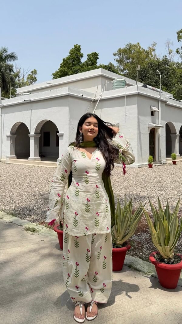 Model posing outdoors wearing an off-white pure Cameric cotton Farshi salwar suit set with a green dupatta.